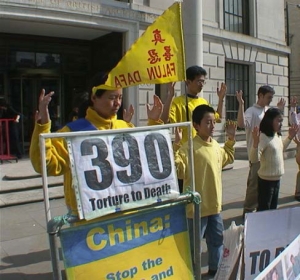 De tienjarige Ben Chen staat naast zijn moeder en andere Falun Gong beoefenaars terwijl ze de rustige meditatie oefeningen doen tegenover de ambassade. (Bron: minghui.org)