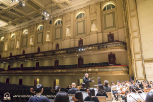 Na New York reisde het orkest naar Boston. Hier begeleidt dirigent Milen Nachev een repetitie op het podium in Boston Symphony Hall.