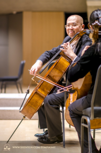 Op het podium in Toronto warmt cellist Yong Deng warmt zich op.