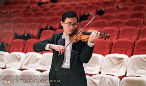 Violist Ian Zhong warmt op voor het concert.