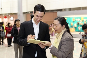 Presentator Ben Freed zet een handtekening.