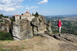 Danseres Daniella Wollensak poseert bijna 5.000 mijl verderop in Meteora, Griekenland, bij het klooster van St. Stephen. Het gebouw is nu een nonnenklooster en is toegankelijk via een bruggetje. Door de ligging op de top lijkt het gebouw midden in de lucht te hangen. 