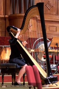 Harpiste Shirley Guo neemt de tijd om haar snaren te stemmen voor het concert.
