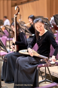 Pipa speelster Miao-Tzu Chiu stemt haar instrument na het opzetten van een nieuwe snaar.