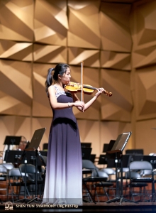 Al omgekleed voor de voorstelling maakt violiste Fiona Zheng gebruik van een laatste kans om op het podium te oefenen.