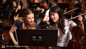 Eerste violiste Rachel Chen (r) en assistent eerste violiste Paulina Cha bespreken het nieuwe encore stuk, toegevoegd voor ons enthousiaste Taiwanese publiek. 