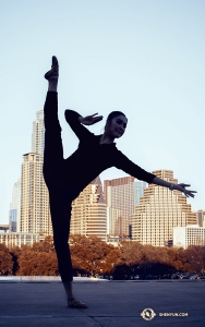 Ondertussen raakt danseres Lily Wang de hemel met haar tenen voor een achtergrond van wolkenkrabbers in Austin, Texas. (Foto door danseres Michelle Wu)