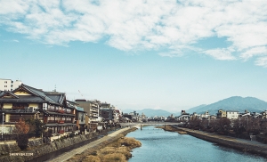  Op weg naar een andere dag van verkenning begint danseres Michelle Wu met het vastleggen van de riviersc&egrave;ne naast het Gion Station van Kyoto. 