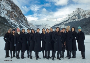 Vijftien koukleumende dansers poseren samen bij Lake Louise in Banff, Canada. (Foto door Regina Dong)